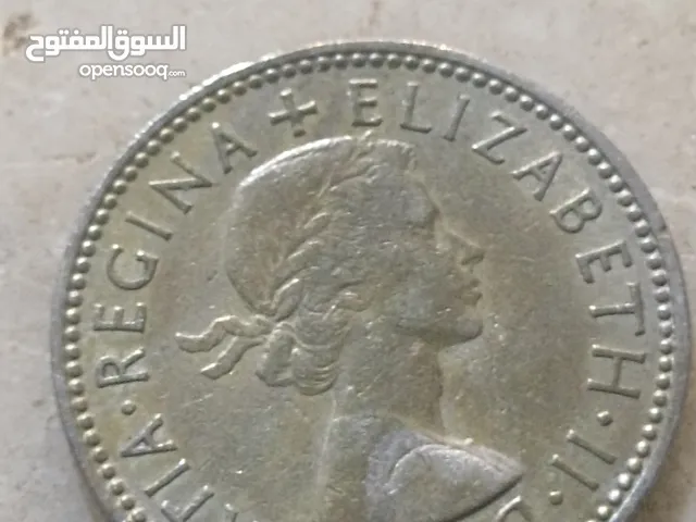 تُظهر الصورة عملة شلن بريطانية تعود لعام 1958. كان الشلن البريطاني، الذي يُختصر بـ "1s" أو "1/-"،
