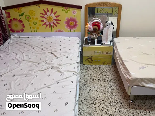 Two single beds with headboards and cabinet and bedside drawer