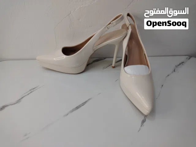 هذا الحذاء هو حذاء نسائي بكعب عالٍ ومقدمة مدببة وحزام خلفي، مشابه لموديلات "تشارلز آند كيث" بلون طبش