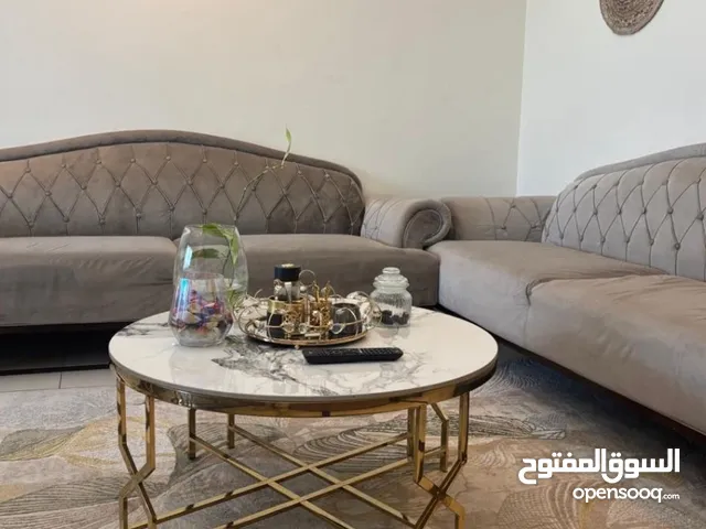 2 grey sofas and a dining table with no chairs