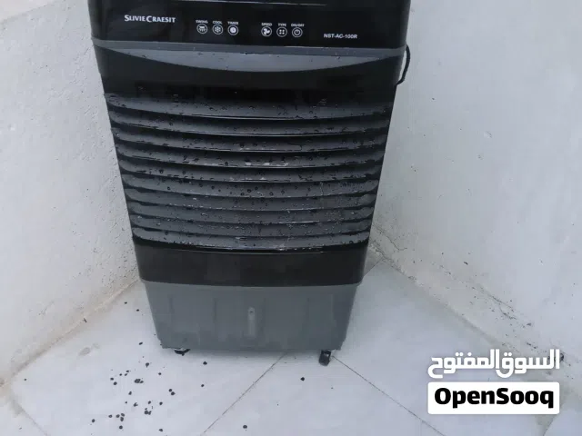 مبردة صغيرة الحجم تشتغل على كهرباء لتبريد المنزل لون اسود لها عجلتان