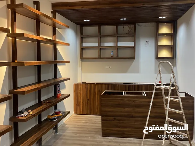 كاونتر خشب وسنك خشب مع ابواب وجرارات ورفوف خشبية حائطية تصلح ديكور محل او رفوف لغرفة