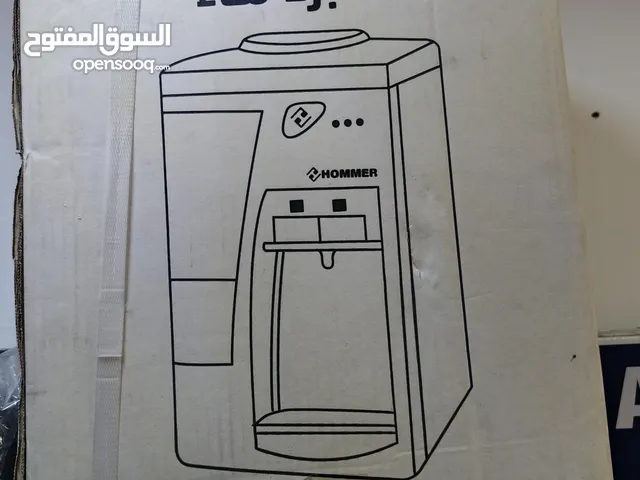 مبرد ماء على الطاولة مع خزان أكواب ورقية