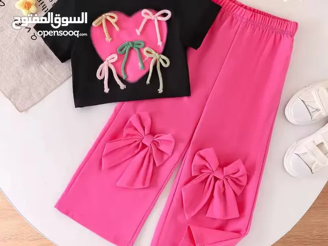 مجموعة بنات أنيقة وعصرية! مكونة من تيشيرت أسود بقلب وردي مزين بفيونكات ملونة وبنطال زهري بفيونكات