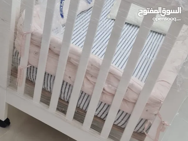 سرير أطفال خشب أبيض – شبه جديد سرير من ماركة JUNIOR، مصنوع من خشب قوي وعجلات سهلة الحركة