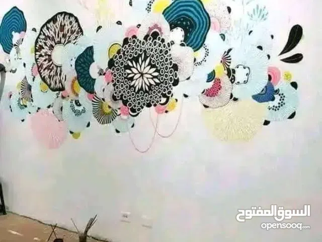 رسام وخطاط علي الجدران