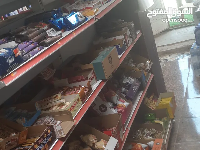 محل غذائية للبيع من غذائيه وبرادات ورفوف ومواد غذائيه كاملا مع ميز كاشير خشب ومبرده ومكتبه خشبيه...