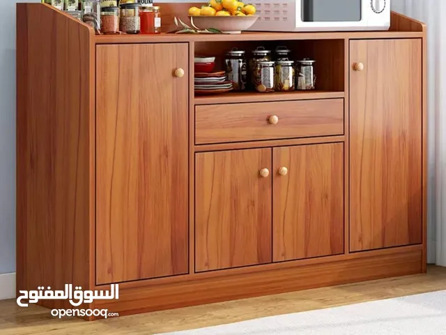 خزانة عملية مع مقابض خشبية بسيطة وأنيقة  تصميمها يجمع بين المساحات المغلقة والرفوف المفتوحة