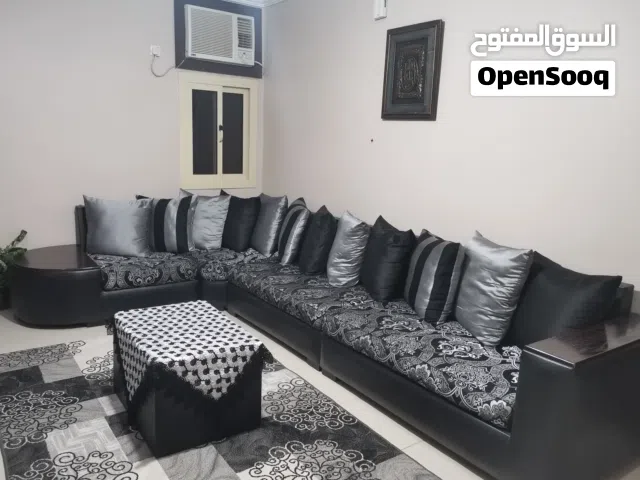 طقم كنب مع طاولة وسجادة وفازة كبيرة