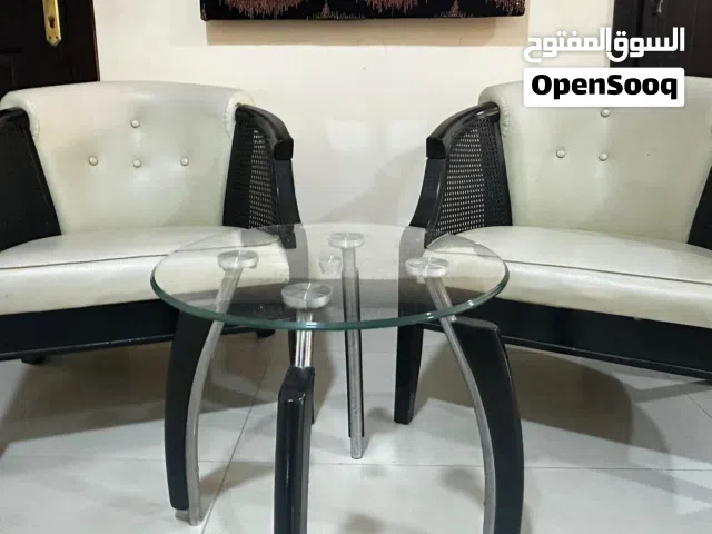 Two leather chairs with glass table.
