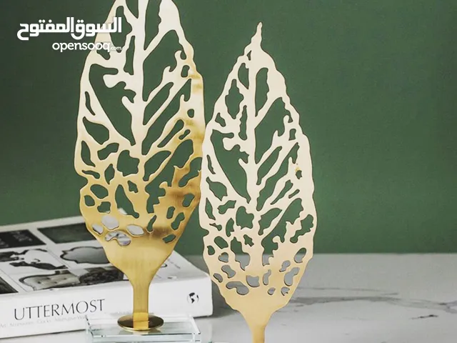 تحفة ذهبية بقاعدة كريستال تحفة فنية أنيقة بتصميم ورقة شجر مجوفة بلون ذهبي فاخر .