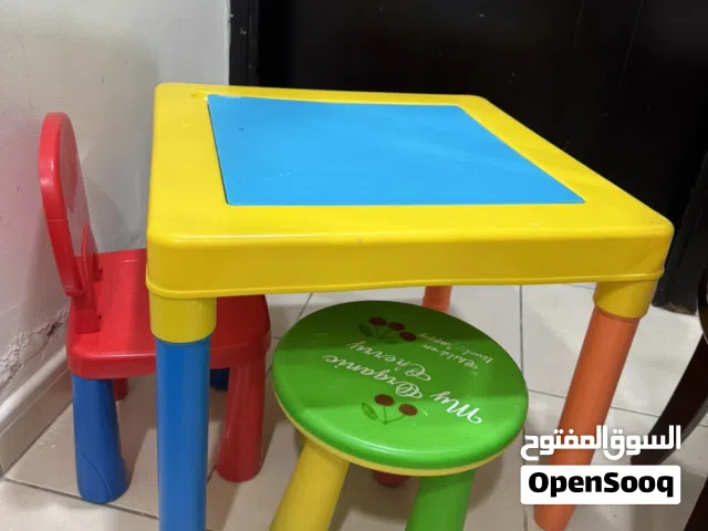 طاوله كبيره مع كرسي باللون الاحمر وكرسي صغير باللون الأخضر