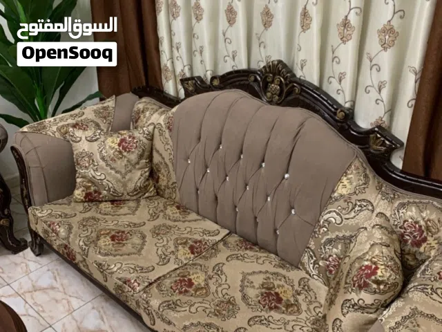 طقم كنب لغرفة ضيوف من 7 مقاعد، و ساعة خشبية أرضية.