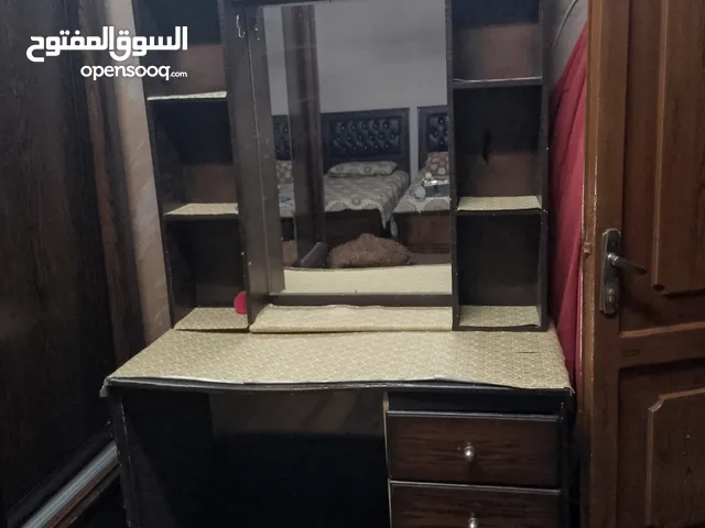 مكتب فيه مراي ورفوف وثلاث جوارير