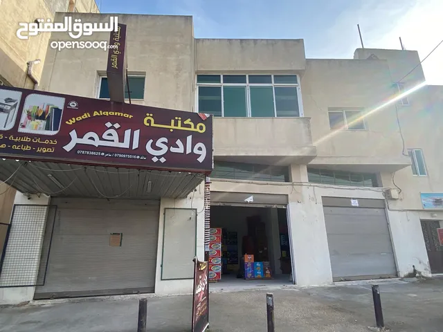 مجمع سكني على الشارع الرئيسي شقتين و 6 مخازن مؤجرات و حديقه و موقف سيارة