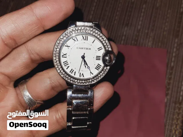 ساعه كارتير Cartier، وخصوصًا موديل Ballon Bleu المعروف بالتاج الدائري الجانبي والأرقام الرومانية.