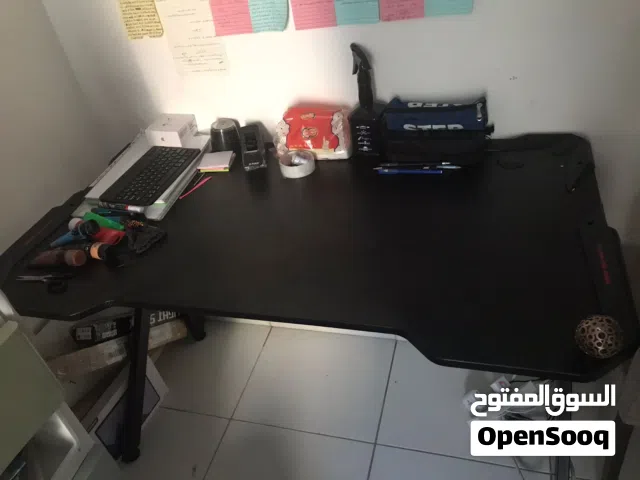 مكتب للدراسة او الجيمنج اسود اللون مع بعض التفاصيل باللون الأحمر مع حامل اكواب و حامل لسماعا الجيمنج