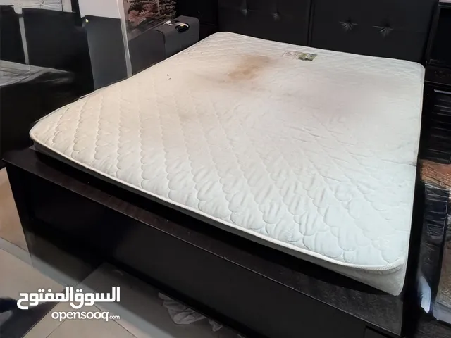 سرير غرفة نوم و مرتبة و برادي معتمة و حامل متحرك للتليفزيون.