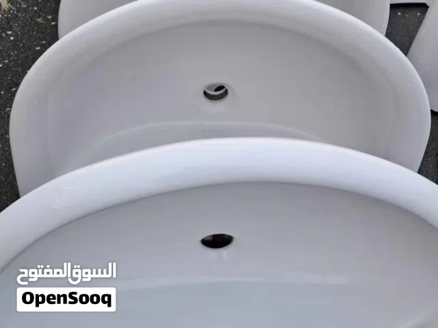 احوض غسيل سيراميك للحمامات أبيض اللون يُركب على الحائط، ويتميز بتصميم نصف دائري أو منحني