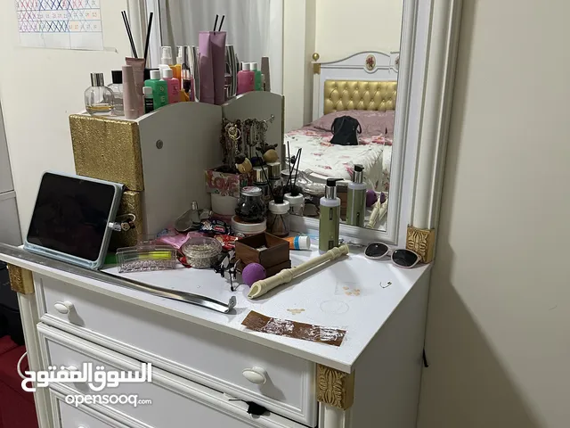 Two study tables, a chest of drawers, and a dressing table with a mirror.