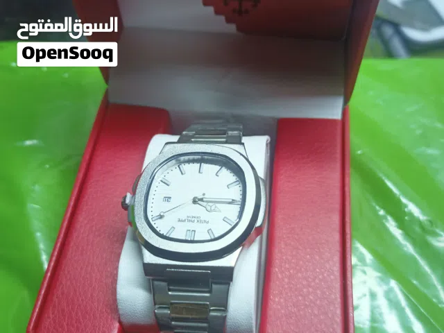 الساعة بتصميم Patek Philippe Nautilus الأيقوني مع ميناء أبيض وعلامات ساعة سوداء. [1, 2]  تأتي الساعة