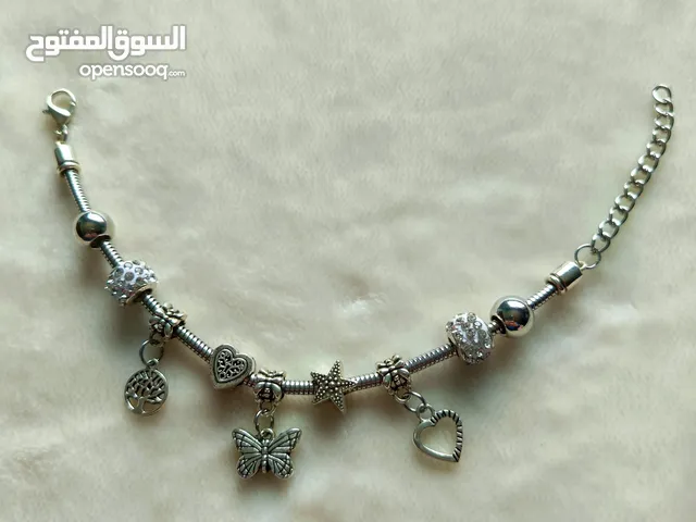 اسوارة ستيل لون فضي مع تعليقات ستيل متنوعة ومرصّعة